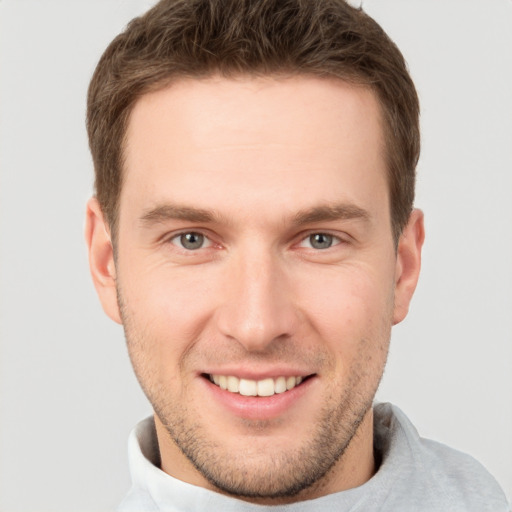 Joyful white young-adult male with short  brown hair and grey eyes