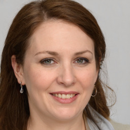 Joyful white adult female with long  brown hair and grey eyes