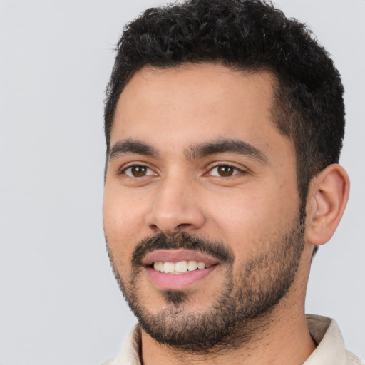 Joyful latino young-adult male with short  black hair and brown eyes