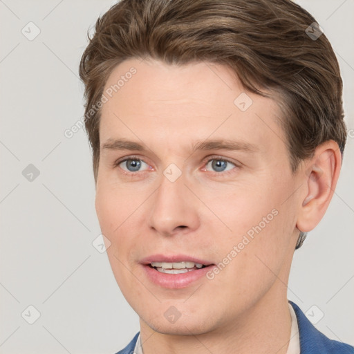 Joyful white young-adult male with short  brown hair and grey eyes