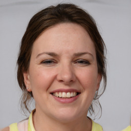 Joyful white adult female with medium  brown hair and blue eyes