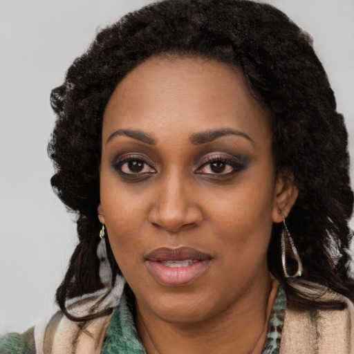 Joyful black young-adult female with long  black hair and brown eyes