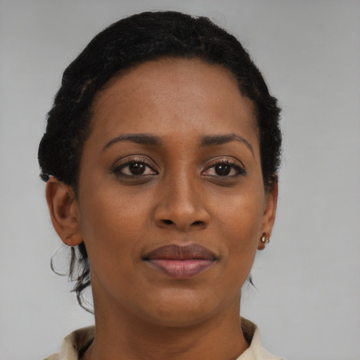 Joyful black young-adult female with short  brown hair and brown eyes