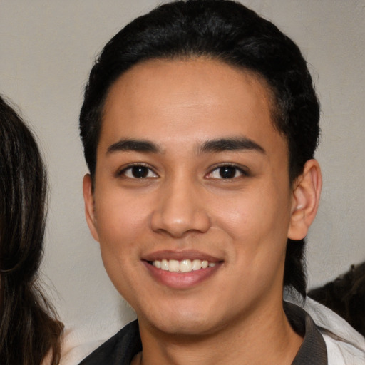 Joyful latino young-adult male with medium  black hair and brown eyes