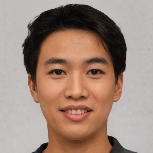 Joyful asian young-adult male with short  black hair and brown eyes