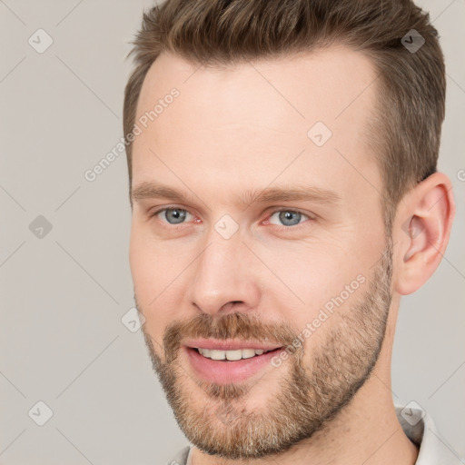 Joyful white young-adult male with short  brown hair and grey eyes