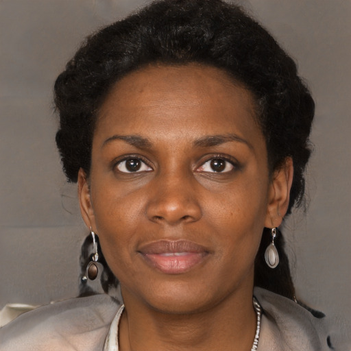Joyful black young-adult female with long  black hair and brown eyes