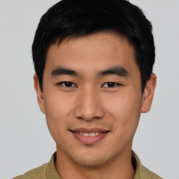 Joyful asian young-adult male with short  black hair and brown eyes