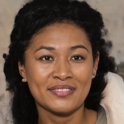 Joyful black young-adult female with long  brown hair and brown eyes