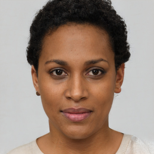 Joyful black young-adult female with short  black hair and brown eyes
