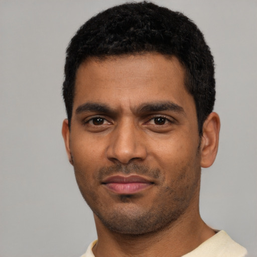 Joyful black young-adult male with short  black hair and brown eyes