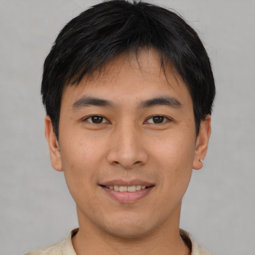 Joyful asian young-adult male with short  brown hair and brown eyes