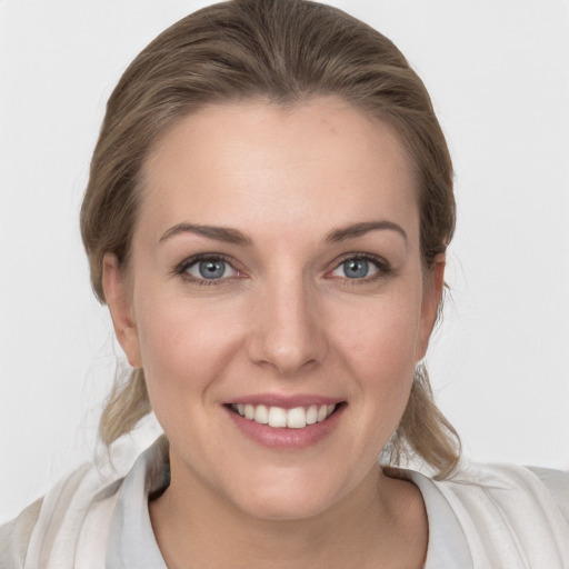 Joyful white young-adult female with medium  brown hair and grey eyes