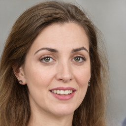 Joyful white young-adult female with long  brown hair and green eyes