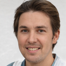 Joyful white adult male with short  brown hair and brown eyes