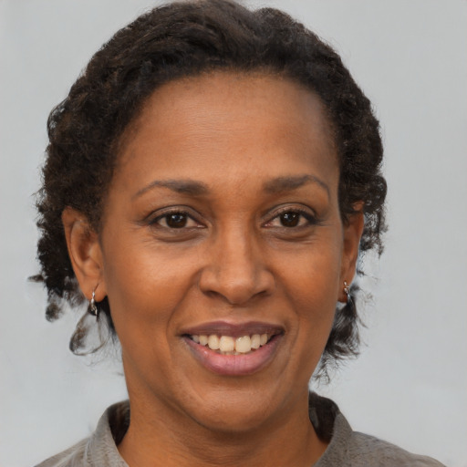 Joyful black adult female with short  brown hair and brown eyes
