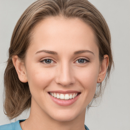 Joyful white young-adult female with medium  brown hair and grey eyes