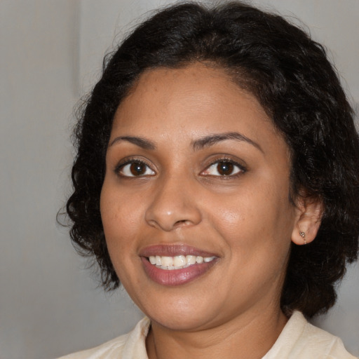 Joyful black young-adult female with medium  brown hair and brown eyes