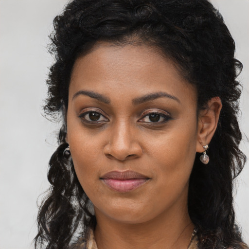 Joyful black young-adult female with long  brown hair and brown eyes