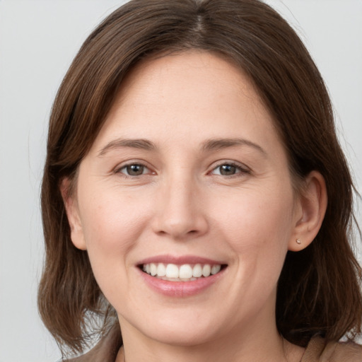 Joyful white young-adult female with medium  brown hair and grey eyes