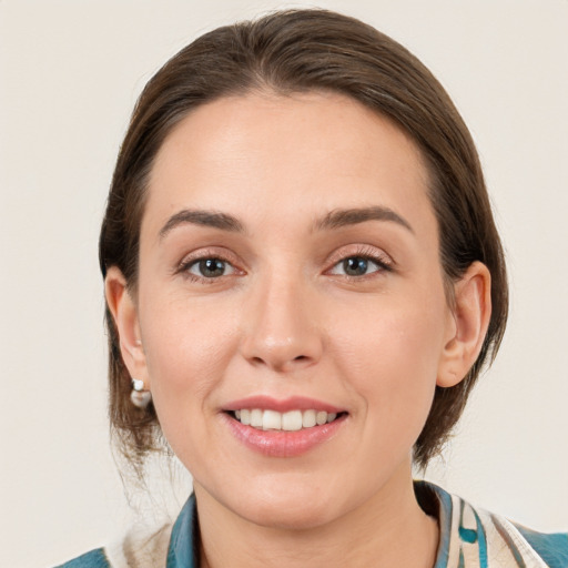 Joyful white young-adult female with medium  brown hair and grey eyes