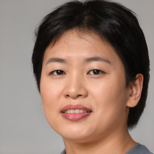 Joyful asian young-adult female with medium  brown hair and brown eyes