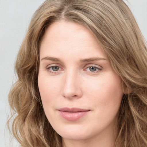 Joyful white young-adult female with long  brown hair and green eyes