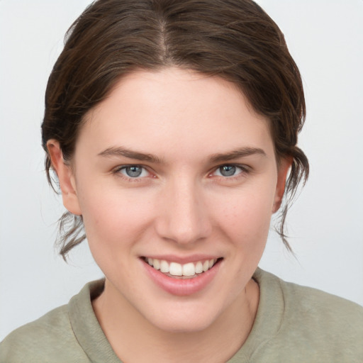 Joyful white young-adult female with medium  brown hair and grey eyes