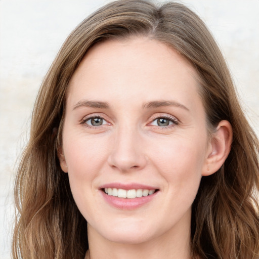 Joyful white young-adult female with long  brown hair and blue eyes