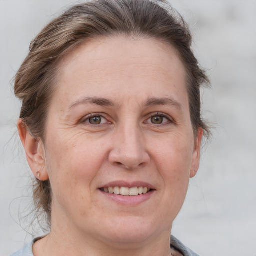 Joyful white adult female with medium  brown hair and grey eyes