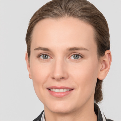 Joyful white young-adult female with medium  brown hair and grey eyes