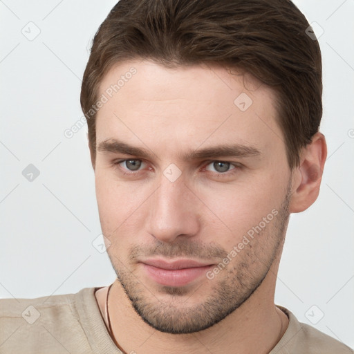 Joyful white young-adult male with short  brown hair and grey eyes