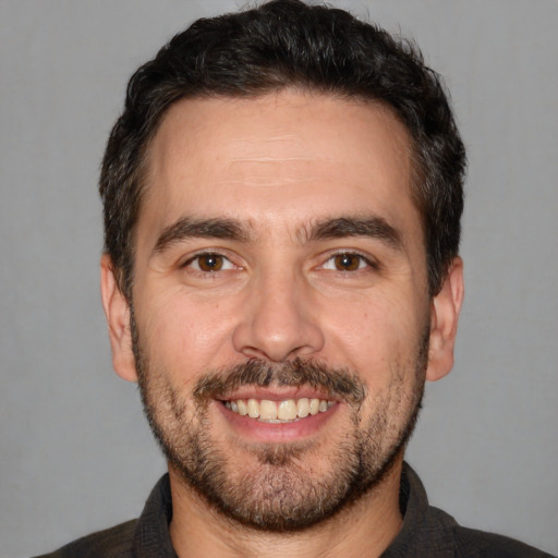 Joyful white adult male with short  black hair and brown eyes