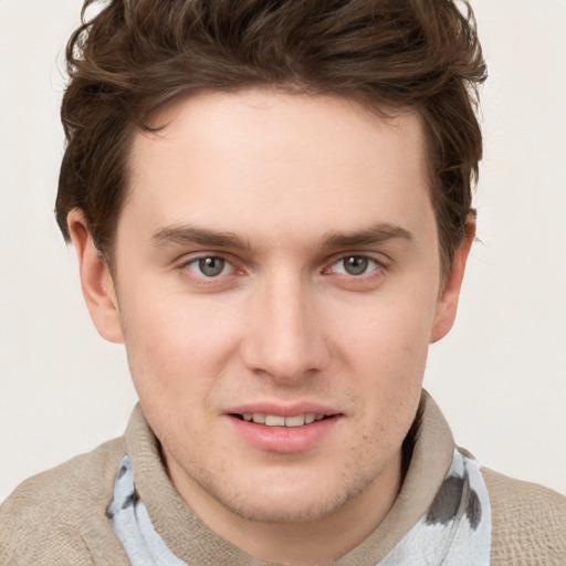 Joyful white young-adult male with short  brown hair and blue eyes