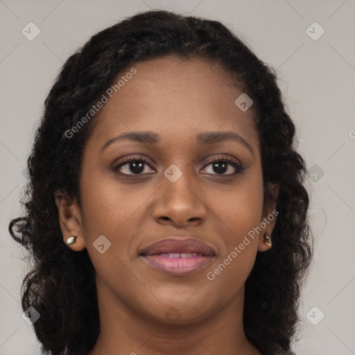 Joyful black young-adult female with long  brown hair and brown eyes