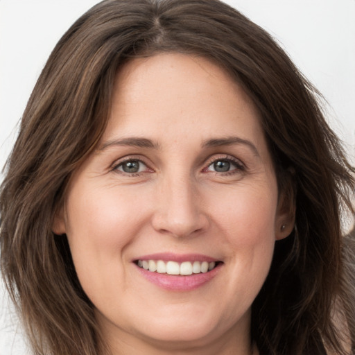 Joyful white young-adult female with long  brown hair and grey eyes