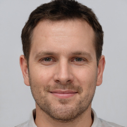 Joyful white adult male with short  brown hair and brown eyes