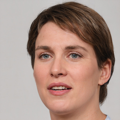 Joyful white young-adult female with medium  brown hair and green eyes