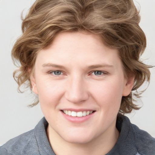 Joyful white young-adult female with medium  brown hair and blue eyes