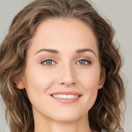 Joyful white young-adult female with long  brown hair and green eyes