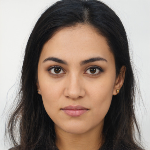 Joyful latino young-adult female with long  brown hair and brown eyes
