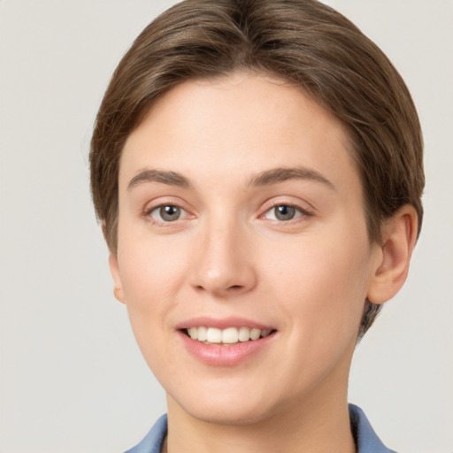 Joyful white young-adult female with short  brown hair and grey eyes