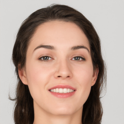 Joyful white young-adult female with long  brown hair and grey eyes