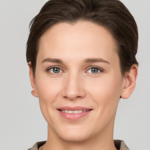 Joyful white young-adult female with short  brown hair and grey eyes