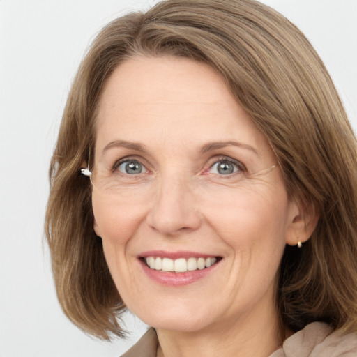 Joyful white adult female with medium  brown hair and grey eyes