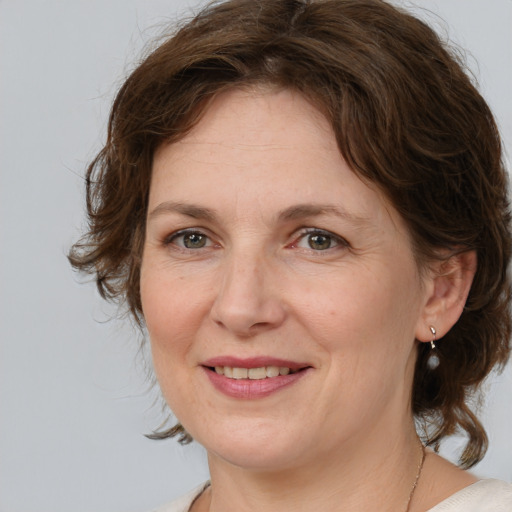 Joyful white adult female with medium  brown hair and grey eyes