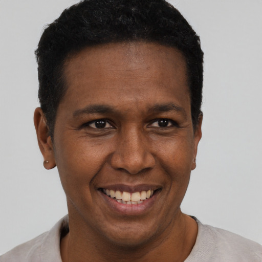 Joyful black young-adult male with short  black hair and brown eyes