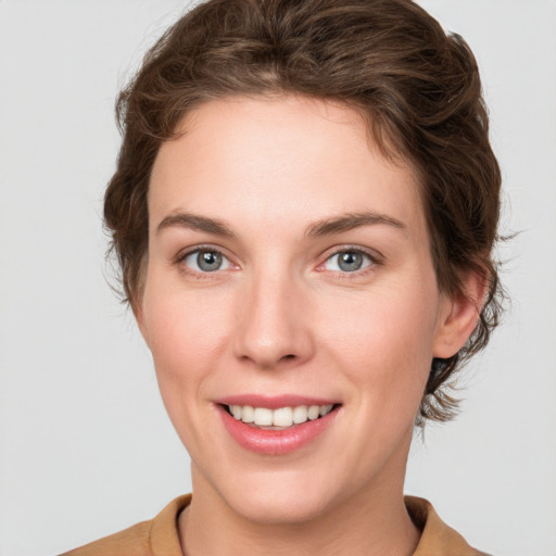 Joyful white young-adult female with short  brown hair and green eyes