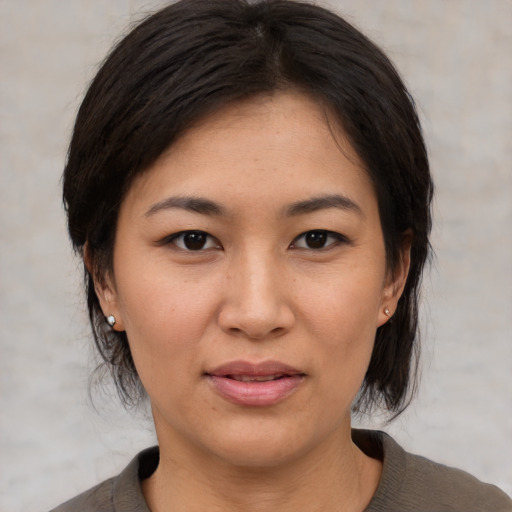 Joyful asian young-adult female with medium  brown hair and brown eyes