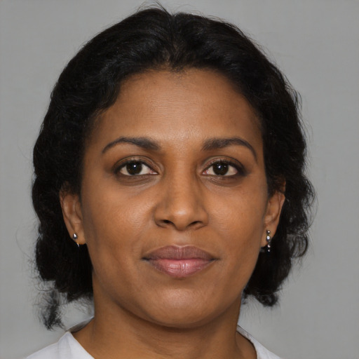 Joyful black adult female with medium  brown hair and brown eyes